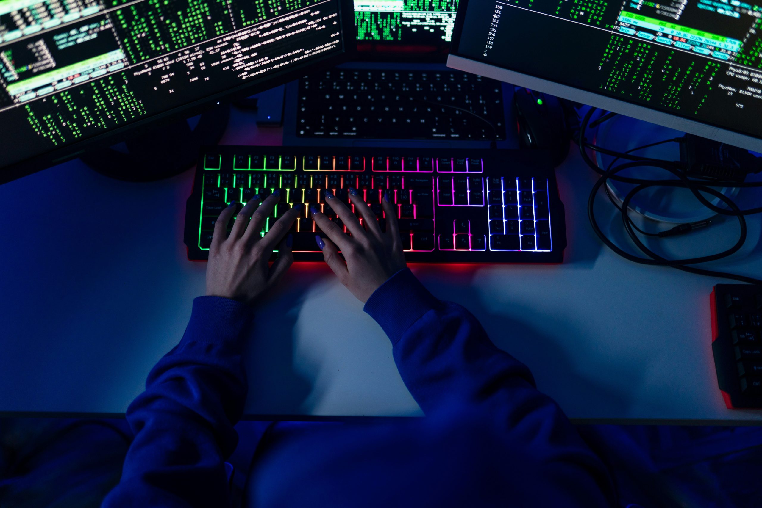 Photo of hands on a keyboard in a darkened room. (Unsplash)